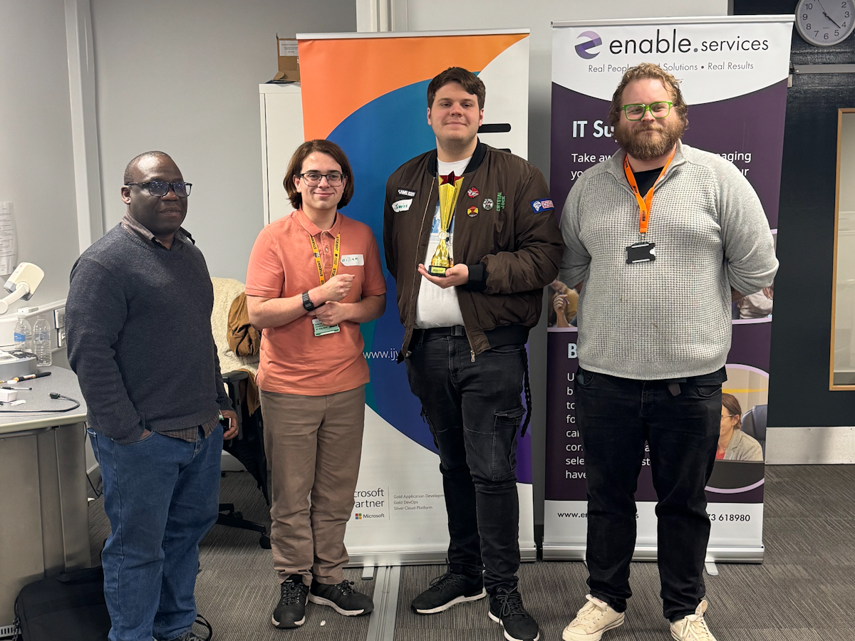 Winners of the hackathon, William King and Travis Brown, with Felix Ngobigha (University of Suffolk) and organiser Lewis Huxtable (IJYI)